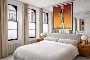 Large wall mirror installed behind a bed to reflect light in a bedroom