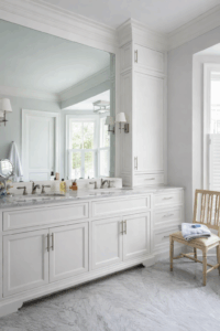Large wall mirror installed above a double vanity in a bright bathroom